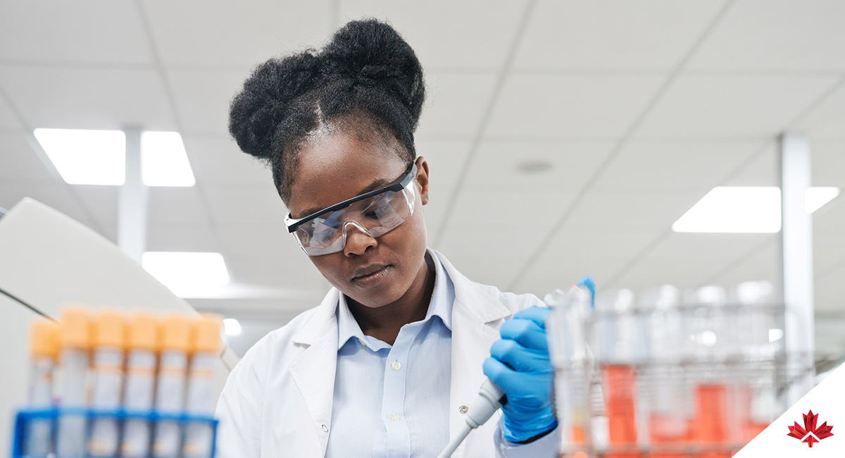 Young female scientist filling chemical through pipette while working in laboratory.