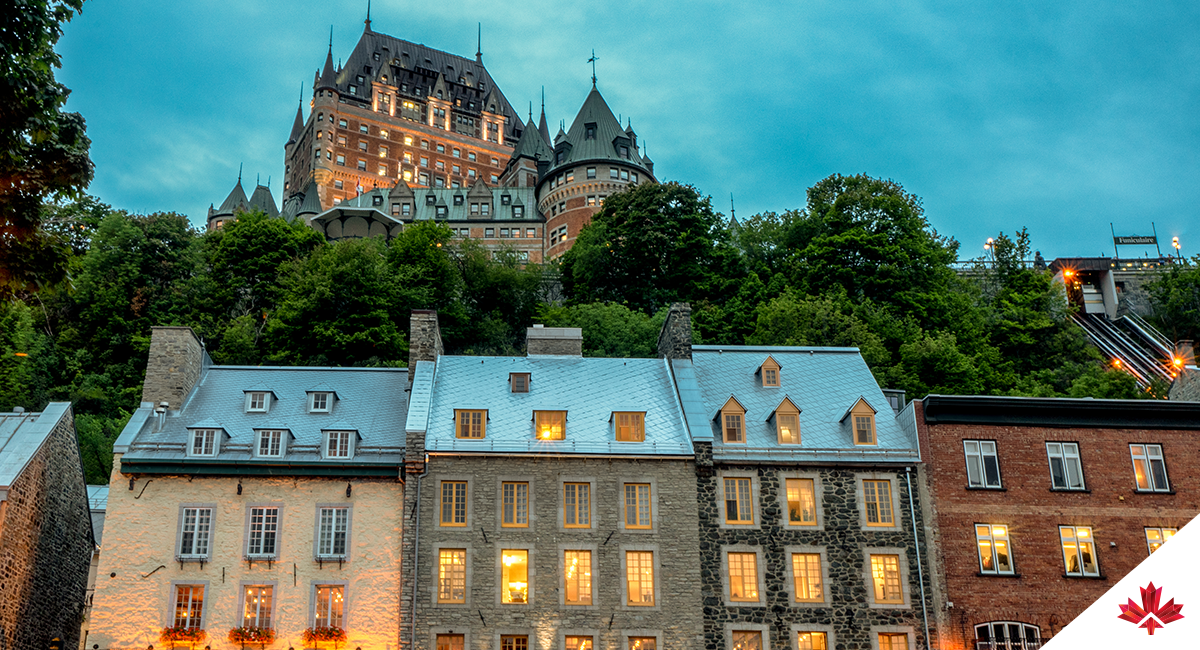 Historic Chateau Frontenac atop restaurants and shops in old town Québec City Canada, in early evening light.